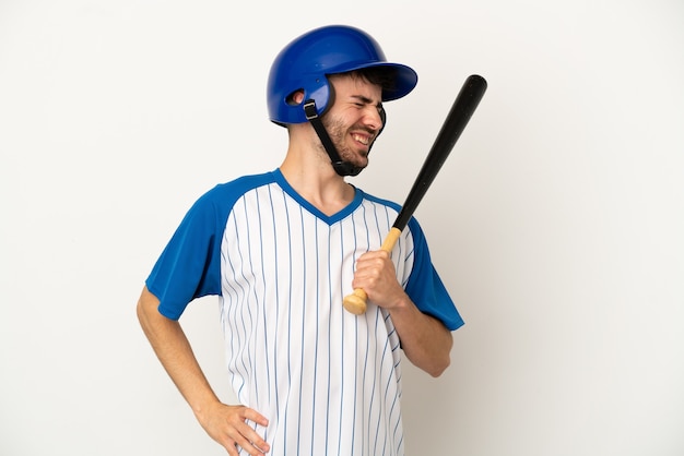 Jonge blanke man die honkbal speelt geïsoleerd op een witte achtergrond die lijdt aan rugpijn omdat hij zijn best heeft gedaan