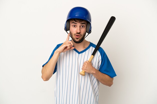 Jonge blanke man die honkbal speelt geïsoleerd op een witte achtergrond met de bedoeling de oplossing te realiseren terwijl hij een vinger opheft