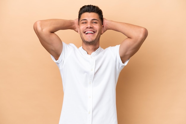 Jonge blanke man geïsoleerd op beige achtergrond lachen