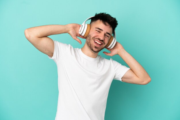 Jonge blanke man geïsoleerd op blauwe achtergrond muziek luisteren