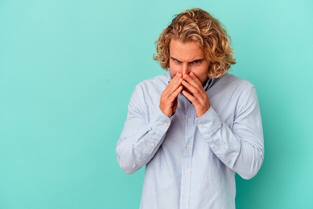 Jonge blanke man geïsoleerd op een blauwe achtergrond die een plan in gedachten maakt, een idee opzet.