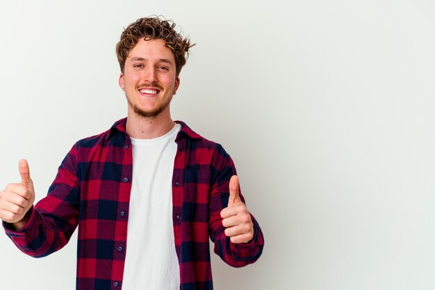 Jonge blanke man geïsoleerd op een witte achtergrond glimlachend en duim opheffen