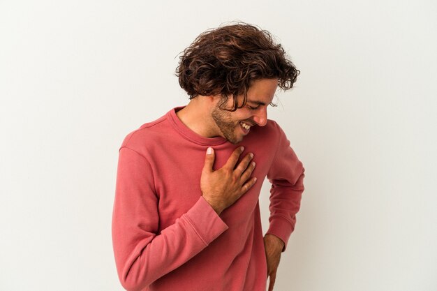 Jonge blanke man geïsoleerd op een witte achtergrond lachen houden handen op het hart, concept van geluk.