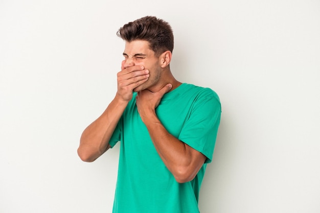 Jonge blanke man geïsoleerd op een witte achtergrond lijdt pijn in de keel als gevolg van een virus of infectie.