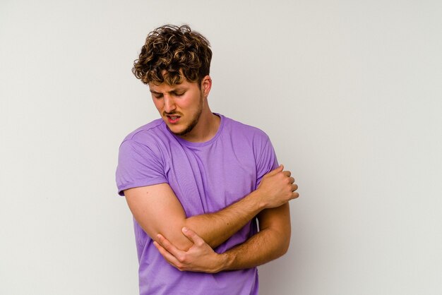 Jonge blanke man geïsoleerd op een witte achtergrond masseren elleboog, lijden na een slechte beweging.