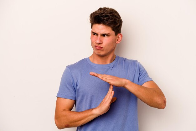 Jonge blanke man geïsoleerd op een witte achtergrond met een time-out gebaar