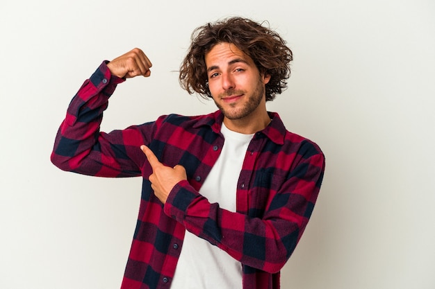 Jonge blanke man geïsoleerd op een witte achtergrond met kracht gebaar met armen, symbool van vrouwelijke kracht