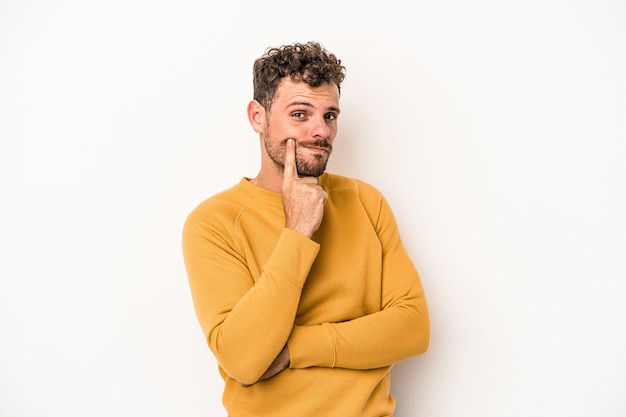 Jonge blanke man geïsoleerd op een witte achtergrond overweegt, het plannen van een strategie, denken over de manier van een bedrijf.