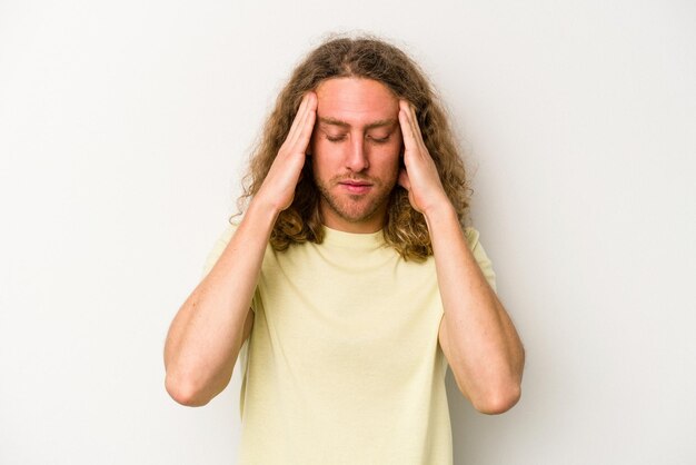 Jonge blanke man geïsoleerd op een witte achtergrond tempels aan te raken en hoofdpijn te hebben