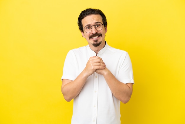 Jonge blanke man geïsoleerd op gele achtergrond lachen