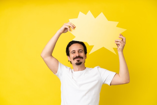 Jonge blanke man geïsoleerd op gele achtergrond met een lege tekstballon