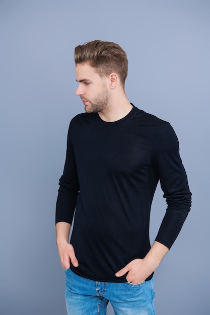 Jonge blanke man geïsoleerd op grijs Zelfverzekerde man gezicht portret Mannen huidverzorging Huidverzorgdheid van mannen Man heeft stijlvol kapsel Man met trendy kapsel Casual mannelijke stijl Opvallend knap