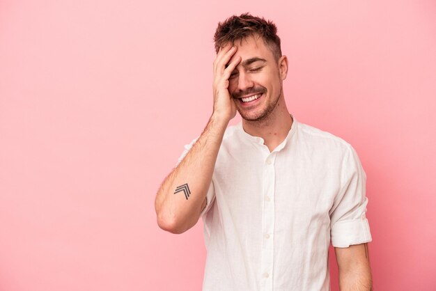 Jonge blanke man geïsoleerd op roze achtergrond lachen gelukkig, zorgeloos, natuurlijke emotie.