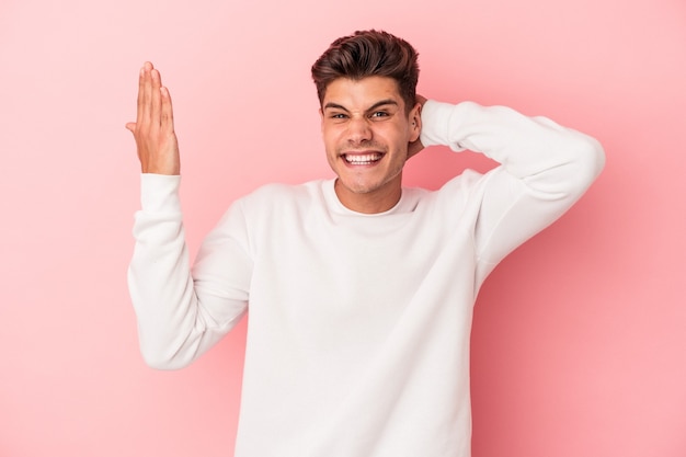 Jonge blanke man geïsoleerd op roze achtergrond schreeuwen van woede.