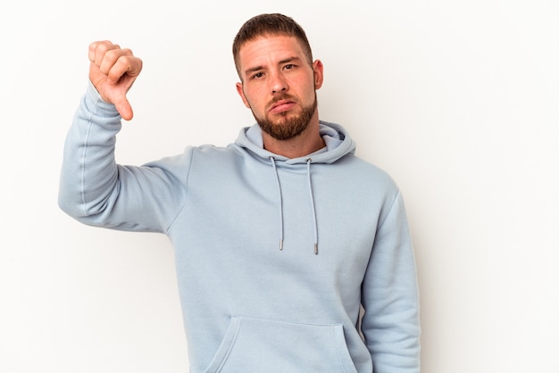 Jonge blanke man met diastema geïsoleerd op een witte achtergrond met een afkeer gebaar, duim omlaag. onenigheid begrip.