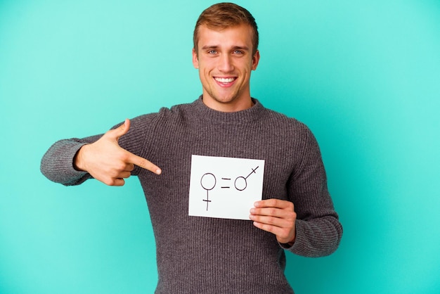 Jonge blanke man met een banner voor gendergelijkheid geïsoleerd op blauwe achtergrond