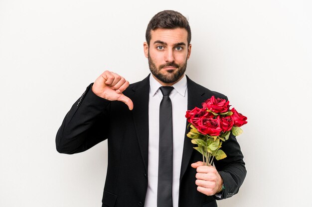 Jonge blanke man met een boeket bloemen geïsoleerd op een witte achtergrond met een afkeer gebaar duim omlaag meningsverschil concept