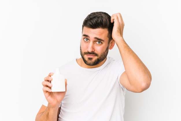 Jonge blanke man met een fles vitaminen geïsoleerd geschokt, ze heeft belangrijke bijeenkomst herinnerd.