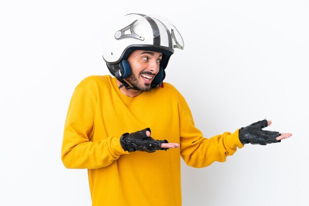 Jonge blanke man met een motorhelm geïsoleerd op een witte achtergrond met verrassingsuitdrukking terwijl hij opzij kijkt