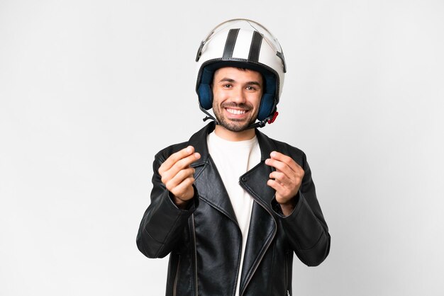 Jonge blanke man met een motorhelm over geïsoleerde witte achtergrond die geldgebaar maakt