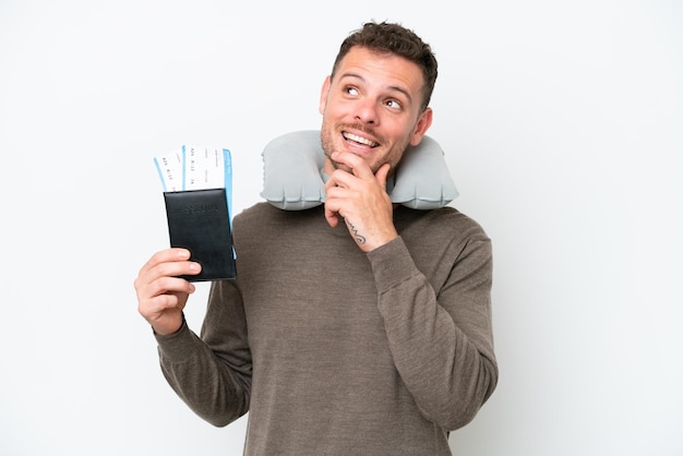 Jonge blanke man met een paspoort geïsoleerd op een witte achtergrond terwijl hij glimlacht