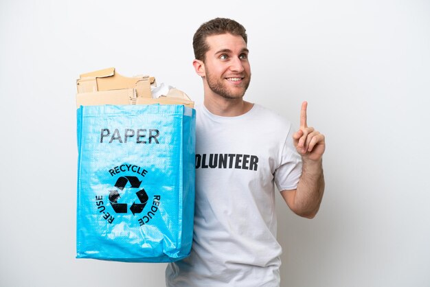 Jonge blanke man met een recyclingzak vol papier om te recyclen geïsoleerd op een witte achtergrond die een geweldig idee benadrukt