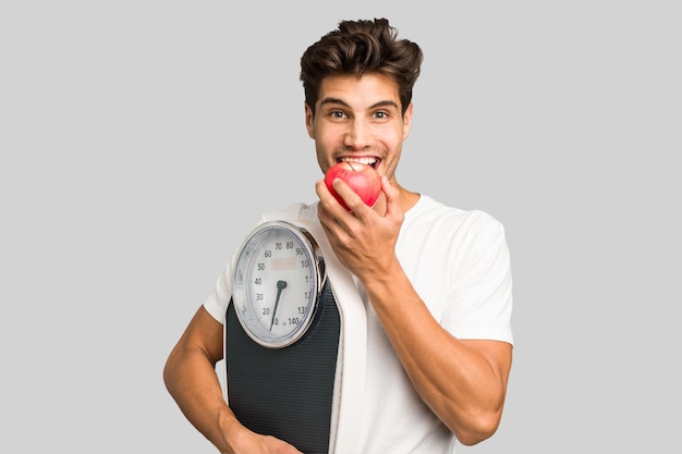 Jonge blanke man met een schaal en een appel geïsoleerd