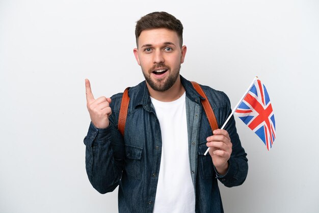 Jonge blanke man met een vlag van het Verenigd Koninkrijk geïsoleerd op een witte achtergrond, denkend aan een idee met de vinger omhoog