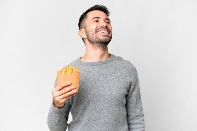 Jonge blanke man met gebakken chips over een geïsoleerde witte achtergrond lachend