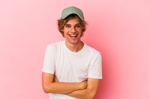 Jonge blanke man met make-up geïsoleerd op roze achtergrond lachen en plezier hebben.