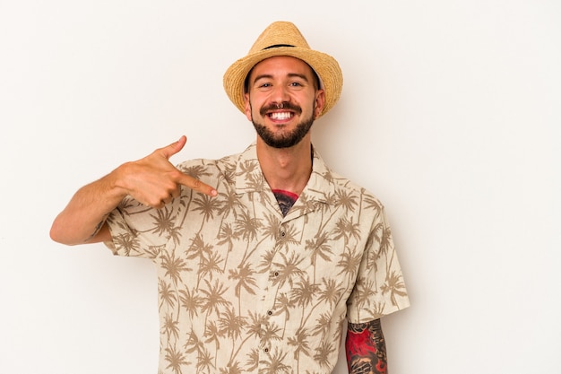 Jonge blanke man met tatoeages met zomerkleren geïsoleerd op een witte achtergrond persoon die met de hand wijst naar een shirt kopieerruimte, trots en zelfverzekerd?