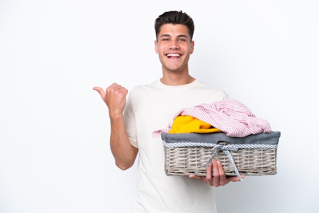 Jonge blanke man met wasmand geïsoleerd op een witte achtergrond wijzend naar de zijkant om een product te presenteren