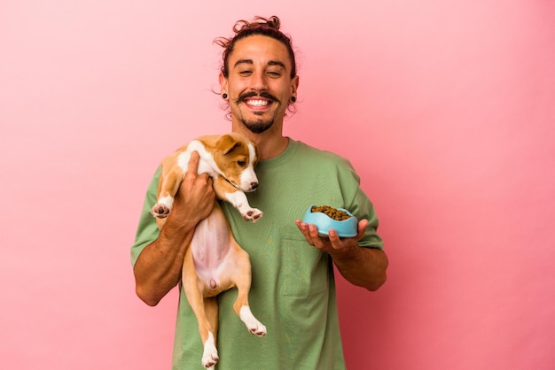 Jonge blanke man met zijn puppy en zijn eten geïsoleerd op roze achtergrond