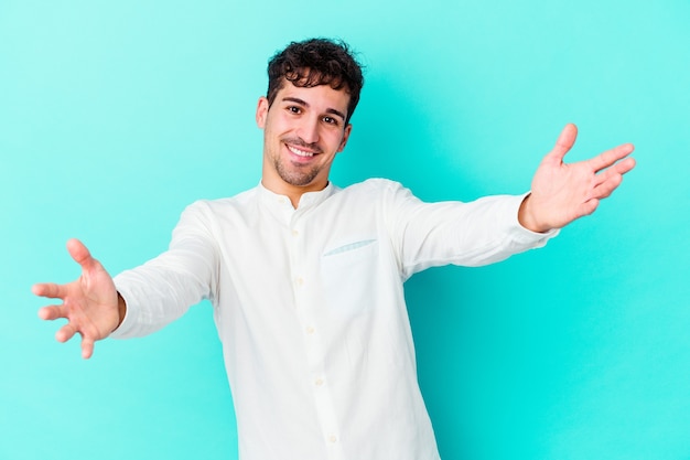 Jonge blanke man op blauw voelt zich zelfverzekerd en geeft een knuffel