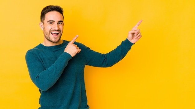 Jonge blanke man op gele muur dansen en plezier maken.