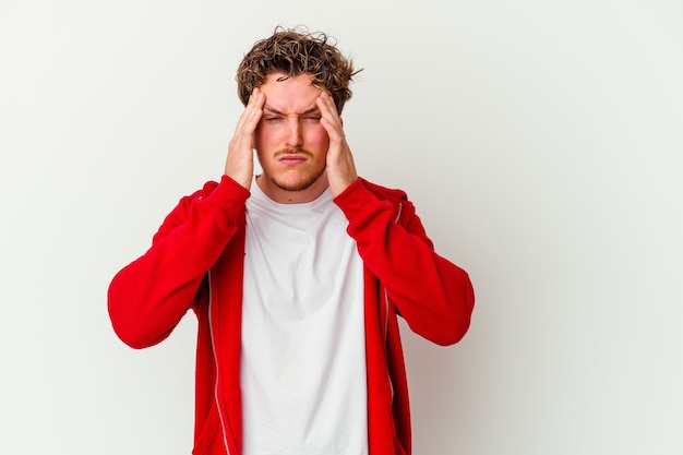 Jonge blanke man op wit tempels aan te raken en hoofdpijn te hebben.