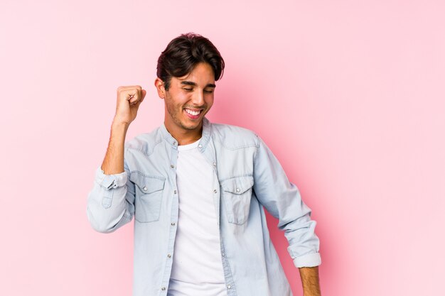 Jonge blanke man poseren in een roze muur dansen en plezier.