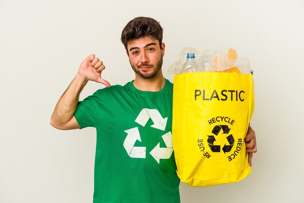 Jonge blanke man recycling van plastic geïsoleerd op een witte achtergrond voelt zich trots en zelfverzekerd, voorbeeld te volgen.