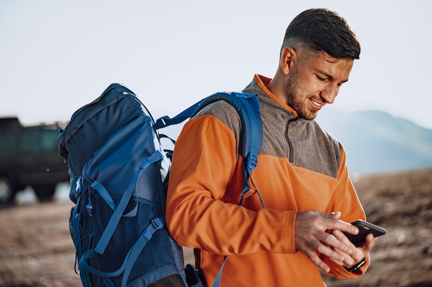 Jonge blanke man reiziger met behulp van zijn smartphone, close-up portret
