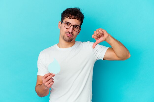 Jonge blanke man viert wereld water dag geïsoleerd met een afkeer gebaar, duimen naar beneden. Meningsverschil concept.