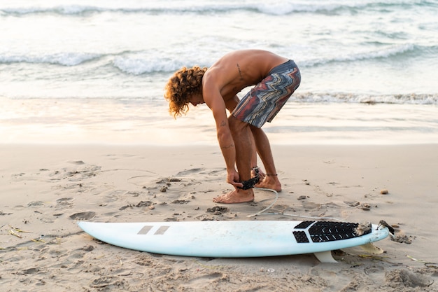 Jonge blanke man vroeg opstaan om te surfen bij zonsopgang