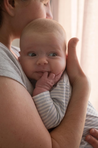 Jonge blanke moeder die haar pasgeboren babymeisje vasthoudt en samen tijd doorbrengt