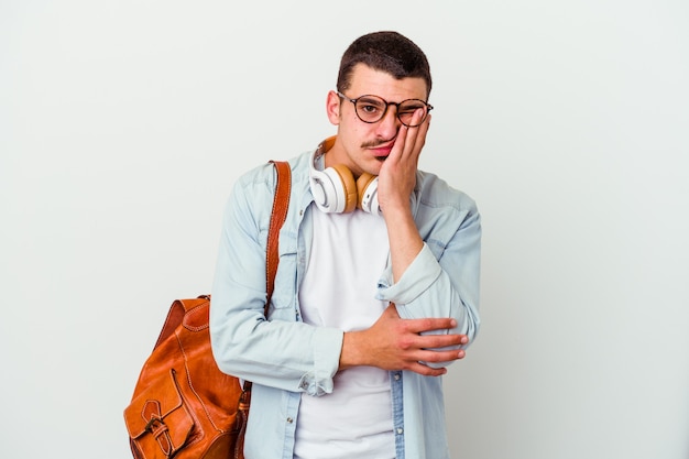 Jonge blanke student man luisteren naar muziek geïsoleerd op een witte achtergrond die zich verveelt, vermoeid is en een ontspannen dag nodig heeft.