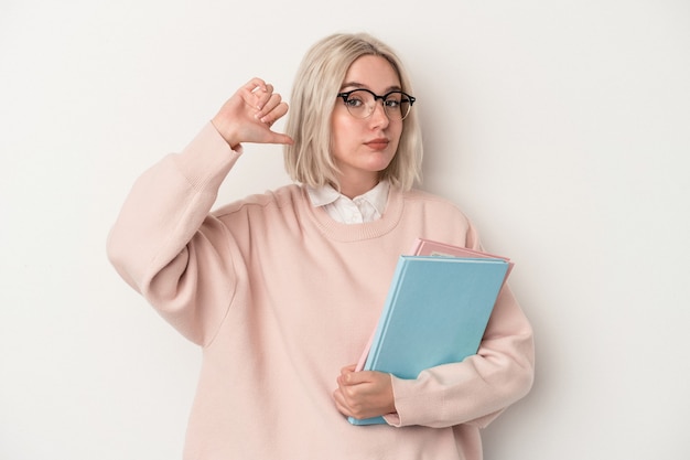 Jonge blanke studentenvrouw met boeken geïsoleerd op een witte achtergrond voelt zich trots en zelfverzekerd, een voorbeeld om te volgen.