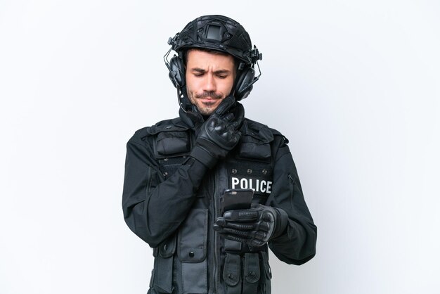 Jonge blanke SWAT man geïsoleerd op witte achtergrond denken en een bericht verzenden