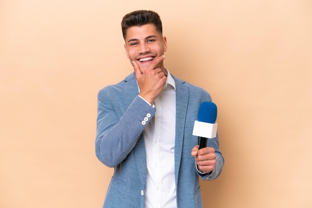 Jonge blanke tv-presentator man geïsoleerd op witte achtergrond gelukkig en glimlachend