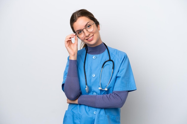 Jonge blanke verpleegster vrouw geïsoleerd op een witte achtergrond met een bril en happy