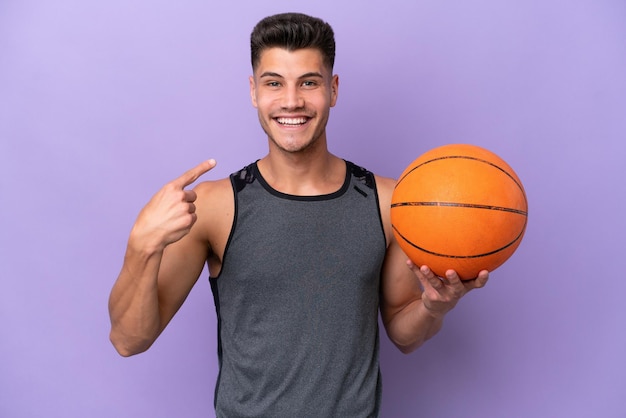 Jonge blanke vrouw basketbalspeler man geïsoleerd op paarse achtergrond geven een duim omhoog gebaar