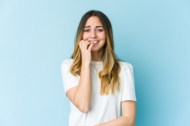 Jonge blanke vrouw bijt nagels, nerveus en erg angstig.