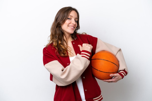 Jonge blanke vrouw die basketbal speelt geïsoleerd op een witte achtergrond trots en zelfvoldaan